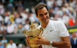 Le Suisse Roger Federer savoure sa victoire, trophée en main, face au Croate Marin Cilic en finale à Wimbledon, le 16 juillet 2017