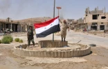 Des combattants syriens pro-gouvernementaux hissent un drapeau syrien à Al-Soukhnah, en Syrie libéré du groupe Etat islamique, le 13 août 2017
