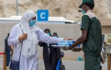 Photo diffusée le 29 juillet 2020 par l'agence de presse saoudienne SPA montrant un employé distribuant des bouteilles d'eau à des femmes venues faire le pèlerinage à La Mecque, lors de leur arrivée au Mont Arafat