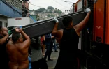Des habitants hissent un corps dans une des favelas du Complexo da Penha, à Rio de Janeiro, le 29 octobre 2025