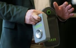 Matthew Mough, directeur de la Mark Twain Middle School, tient la pochette YONDR verrouillable pour les téléphones portables lors d'une interview sur l'interdiction des smartphones dans son établissement, à Alexandria, le 6 mars 2025 en Virginie
