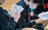 Des jeunes joueurs lisent le manga japonais de volley-ball "Haikyu!!" lors d'une pause pendant un entraînement dans un club de Tokyo, le 13 avril 2024
