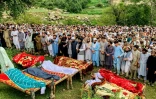 Personnes endeuillées et locaux récitent des prières funéraires pour les victimes décédées lors des crues soudaines dues aux pluies de mousson à Salarzai, dans le district de Bajaur au Pakistan, le 15 août 2025