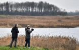Chris Hudson, responsable de la réserve Ouse Fen (g) et le scientifique Richard Gregory observent les oiseaux à la jumelle, le 4 janvier 2022
