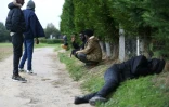 Des migrants dorment ou attendent sur le bord d'un chemin à Ouistreham, près de Caen, le 5 octobre 2017