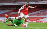 L'attaquant français d'Arsenal Alexandre Lacazette ouvre le score après avoir éliminé le gardien brésilien de Liverpool Alisson Becker, le 15 juillet 2020 à Londres
