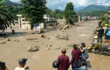 Des habitants observent des maisons partiellement submergées dans des eaux boueuses à la suite d'inondations soudaines survenues à Trishuli Bazar, dans le district de Nuwakot au Népal, le 26 août 2026.