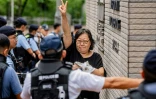 Une femme fait un signe avant d'entrer dans le tribunal pour le procès de militants prodémocratie à Hong Kong, le 21 août 2026