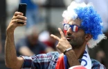 Un supporter fait un selfie sur les Champs-Elysées en attendant l'arrivée des Bleus, le 16 juillet 2018 à Paris