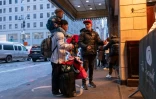 Une famille de migrants devant l'hôtel Roosevelt transformé en centre d'accueil et d'hébergement pour demandeurs d'asile, le 9 janvier 2024 à New York