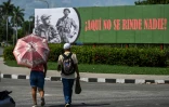 Des Cubains devant une affiche à l'effigie du défunt dirigeant cubain Fidel Castro (1926-2016) et du commandant Juan Almeida Bosque (1927-2009) sur laquelle est écrit "Ici, personne ne se rend", le 19 juin 2026 à La Havane 