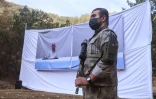Un combattant du PKK devant un portrait d'Abdullah Öcalan, lors d'une cérémonie à Kandil, dans le nord de l'Irak, le 26 octobre 2025