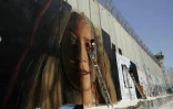 L'artiste de rue italien Jorit Agoch peint un portrait géant d'Ahed Tamimi, une adolescente palestinienne emprisonnée depuis huit mois, sur le mur construit par Israël en Cisjordanie occupée. Photo prise à Bethléem, le 25 juillet 2018