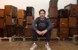 Arthur Verne, fondateur de la société "A.bsolument Vintage Radios", pose au milieu de postes de radio, à Clermont-Ferrand, le 1er décembre 2017
