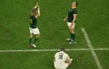 Le demi de mêlée de l'Afrique du Sud Faf de Klerk (à gauche) et le talonneur Deon Fourie (à droite) célèbrent leur victoire devant le pilier anglais Kyle Sinckler (au centre), après la demi-finale remportée contre l'Angleterre 16-15 en demi-finale de la Coupe du monde au stade de France, à Saint-Denis, France, le 21 octobre 2023