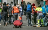 Des membres des services d'urgence aident des migrants à leur arrivée au port de Restinga, sur l'île d'El Hierro, le 18 août 2024 aux Canaries
