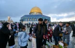 Des bénévoles distribuent des dattes aux musulmans arrivant pour prier à la mosquée al-Aqsa, à Jérusalem, le 10 avril 2024, au premier jour de l'Aïd el-Fitr, la fête marquant la fin du mois de jeûne musulman du ramadan, sur fond de guerre dans la bande de Gaza entre Israël et le mouvement islamiste palestinien Hamas