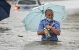 Un homme avance dans une rue inondée de Zhengzhou, placée en alerte rouge après des orages violents qui se sont abattus sur cette métropole du centre de la Chine, le 20 juillet 2021