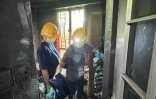 Sur cette photo prise et transmise le 23 avril 2026 par un habitant de Wang Fuk Court, Bowie Chan, son épouse Annie Tse (droite) passe en revue leurs affaires dans leur appartement endommagé par l'incendie de novembre, à Hong Kong
