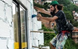 L'artiste français Tarik Bouanani travaille sur une fresque dans le bidonville d'El Pesebre, quartier pauvre et violent de Medellin, en Colombie, le 29 juin 2017 