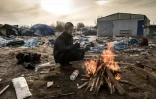 Hemn, un migrant kurde, se réchauffe près d'un feu, le 18 janvier 2016 dans le camp de la "Jungle", à Calais, dans le nord de la France