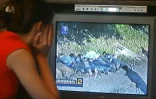 Une femme à Belgrade regarde le 2 juillet 2005 un reportage à la télévision qui montrerait des paramilitaire serbes exécutant six Bosniaques musulmans de Srebrenica