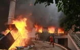 Des manifestants sortent en courant des bureaux du Congrès népalais en flammes, le 9 septembre 2025 à Katmandou