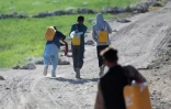 Des habitants transportent des bidons d'eau dans la banlieue de Kaboul, le 27 avril 2025 en Afghanistan