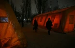 Des habitants passent entre des tentes de secours installées pour les personnes dont les maisons sont privées d'électricité ou de chauffage après des frappes russes contre les infrastructures énergétiques, le 22 janvier 2026 à Kiev, en Ukraine