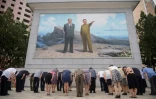 Des Nord-Coréens s'inclinent devant une mosaïque figurant les dirigeants Kim Il Sung et Kim Jong Il, le 8 juillet 2021 à Pyongyang