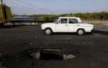Une voiture passe sur un pont à Kiev, endommagé par une frappe de drone russe, le 4 octobre 2026