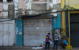 Des vendeurs de rue installés devant des boutiques fermées à Maracaibo