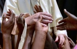 Des enfants touchent la main du pape François qui visite un camp de réfugiés à Bangui le 29 novembre 2015