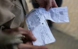 

Le "beachcomber" belge Aäron Fabrice de Kisangani examine des billets d'avion et de train abandonnés par les migrants sur la plage de Gravelines, dans le nord de la France, le 26 mars 2025