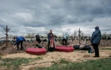Nadia (D) assiste à l'inhumation de son époux et de deux autres personnes tuées, le 18 avril 2022 dans un cimetière de Boutcha, en Ukraine