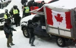 Un policier brise la vitre d'un camion, alors que les autorités tentent de déloger les manifestants d'Ottawa, le 19 février 2022