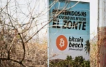 Uneaffiche avec des symboles du Bitcoin accueille les touristes sur la plage d'El Zonte, le 16 mars 2024 au Salvador