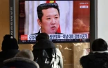 Des personnes regardent une chaîne d'info montrant une photo du leader nord-coréen Kim Jong Un lors d'une réunion du parti au pouvoir à Séoul le 1er janvier 2022