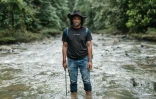 Bokum, membre de la tribu des Hongana Manyawa ("Peuple de la forêt"), au milieu d'une rivière qui, selon les habitants, a été polluée par l'exploitation minière de nickel à East Halmahera, dans le nord des Moluques, le 16 avril 2025 en Indonésie