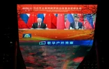 Le président russe Vladimir Poutine à gauche et le président chinois Xi Jinping à droite lors d'un entretien en visioconférence, retransmis sur un écran à Pékin le 4 février 2026