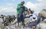 Le créateur de mode Morgan Azedy fouille dans des piles de vêtements mis au rebut dans une décharge à Nairobi, le 6 octobre 2025 au Kenya