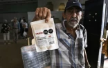 Un homme montre un paquet de viande de poulet sous vide, faisant partie de l’aide humanitaire offerte par le Mexique aux familles cubaines, dans un entrepôt de La Havane, le 6 mars 2026.