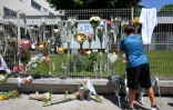 Un élève accroche des fleurs sur les grilles du collège Françoise-Dolto à Nogent, en Haute-Marne, au lendemain du meurtre d'une surveillante, le 11 juin 2025