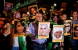 Les familles et proches des victimes de l'incendie de la tour Grenfell portent, un an après le drame, leurs portraits à Londres le 14 juin 2018
