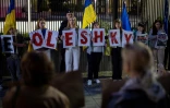 Des membres de la diaspora ukrainienne tiennent des pancartes formant le nom Oleshky (Olechky) devant l'ambassade américaine à Varsovie, le 6 octobre 2026, en Pologne