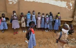 Des enfants portent un masque de protection devant leur école, le 25 mai 2020 à Abidjan, en Côte d'Ivoire