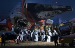 Les secouristes transportent le corps d'un voyageur décédé, après le crash du Boeing 737-800 de Jeju Air, à l'aéroport international de Muan, en Corée du Sud, le 29 décembre 2024.