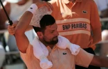 Novak Djokovic pose un sac de glace sur la tête lors de son match de 2e tour contre le Français Valentin Royer, le 27 mai 2026 à Roland-Garros