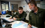 Un pilote stagiaire ukrainien (c) assiste à un briefing pré-vol avec un instructeur militaire français (d) avant un vol à bord d'un avion de combat Alpha Jet, sur une base aérienne de l'armée française, dans le sud-ouest de la France, le 14 juin 2024