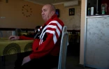 Jovan Zivic est assis dans le petit café qu'il tient dans le village de Plemetina, près d'une centrale thermique au charbon, le 8 avril 2026 au Kosovo
